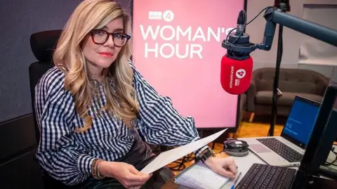 Emma Barnett sitting at her desk