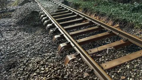 A rail track with ballast washed away underneath it