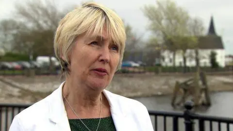 Siân Gwenllian stood to the left of the picture wearing a white jacket and a green top, with a necklace