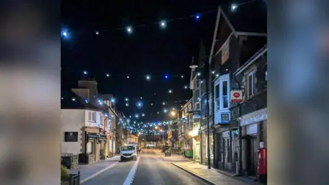 Windermere & Bowness Christmas parade One of the main streets in Windermere with blue Christmas lights twinkling.