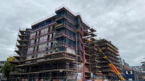 Scaffolding and construction workers at a six-storey development