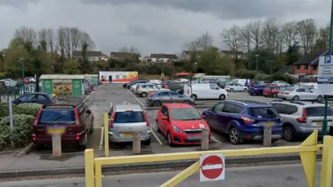 Google The Morrisons car park in Warminster where the mobile breast screening unit was previously situated full of cars with houses and trees in the background.