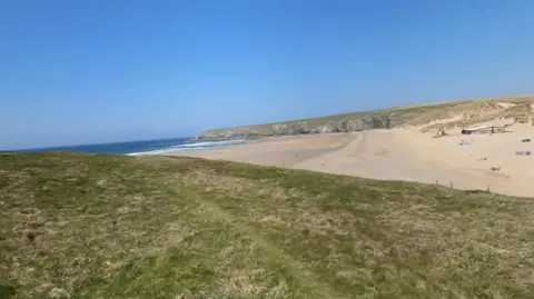 A wide, sandy beach seen from the dunes.