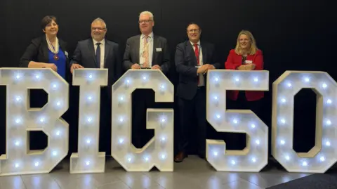 Purple Patch PR Three men in suits and two women stand behind some illuminated giant letters spelling out "Big 50".