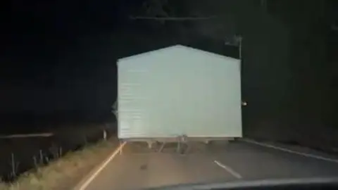 A white static caravan on the road 