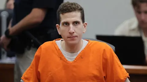 Bryan Kohberger wears an orange prison jumpsuit with a stern expression