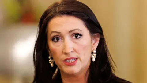 PA Media Emma Little Pengelly with black hair and pearl earrings