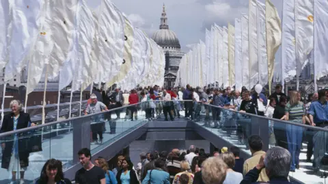 People crossing the bridge on the day it opened in 2000.