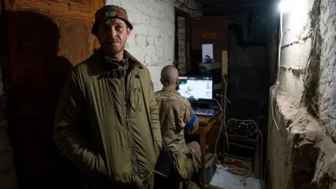 Andrii, drone unit commander, pictured in a basement in Ukraine.