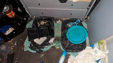 RSPCA Two litter trays covered in rubbish on a carpeted floor