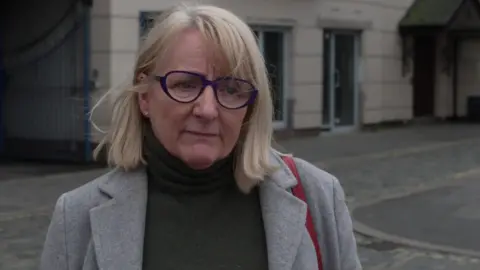 Dawn Jones, provided evidence about her son Timmy wears a grey jacket. She has purple glasses and a blonde bob. 