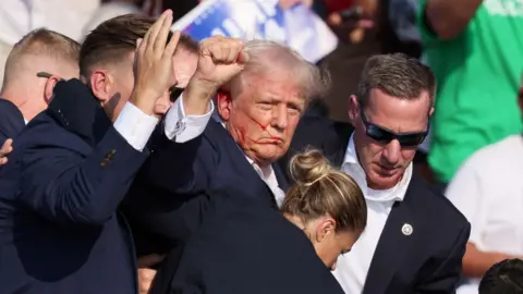 EPA Former US President Donald Trump is rushed off stage by secret service after an incident during a campaign rally at the Butler Farm Show Inc. in Butler, Pennsylvania, USA, 13 July 2024.