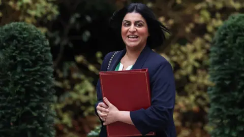 Reuters Home Secretary Shabana Mahmood walks outside Downing Street with a red binder
