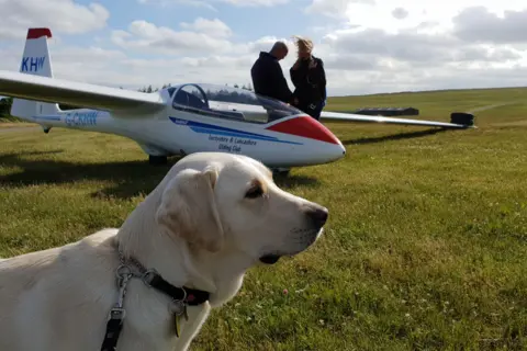 Louann Kent Ugo in front of a glider