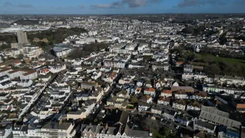 An aerial shot of St Helier's streets of houses, apartment blocks and office buildings.