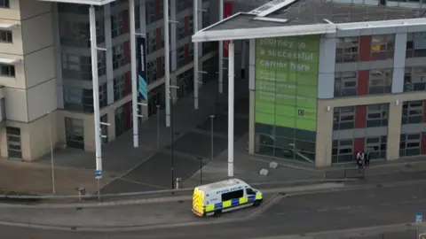 BBC Aerial view of Doncaster College, with a police van parked outside.