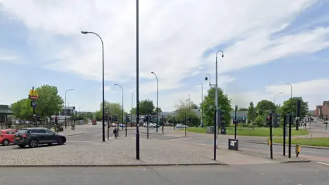 A Google street view image of the junction of Suffolk Road and Granville Road in Sheffield. A McDonald's restaurant is to the left of the image, with a great deal of street furniture such as lamp posts, traffic lights and security cameras. 