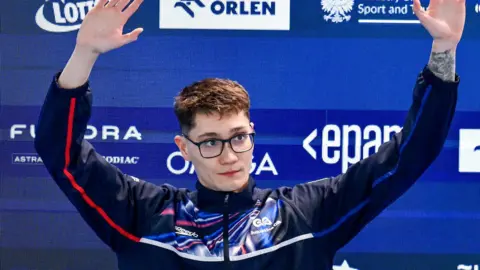 Jack McMillan waves to the crowd as he steps up to receive his gold medal