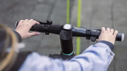 A woman riding an e-scooter