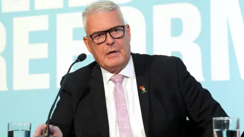 PA Media Lee Anderson speaking into a microphone