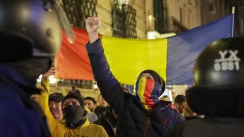 Romanian far-right protesters with national flag confront police in Bucharest