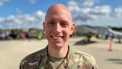 A US Air Force colonel in green camoflauge uniform with Fairford air base in the background