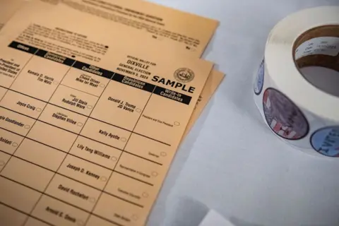 Joseph Prezioso AFP A sample ballot sits on a table as the residents of Dixville Notch prepare to cast their ballots in the US election at midnight in the living room of the Tillotson House at the Balsams Grand Resort, marking the first votes in the US election, in Dixville Notch, New Hampshire on 4 November 2024 