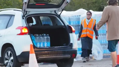 PA Media Bottled water being dispensed to customers