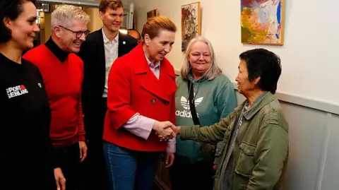 AFP Denmark's Prime Minister and Social Democrats' leader Mette Frederiksen (C) meets Greenlandic voters on election day, in Aalborg, on March 24, 2026
