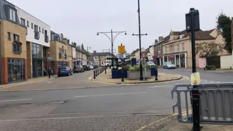 JOHN DEVINE/BBC The Great Whyte is the main hub of Ramsey, it has two-way traffic on the right, which will remain, but to the left, outside the library there is a a single lane with car spaces which is the area that could be pedestrianised losing parking bays.