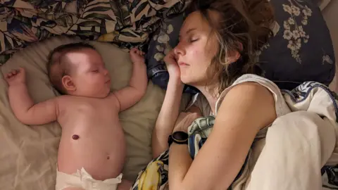 BBC Louise asleep next to her baby, who is also asleep