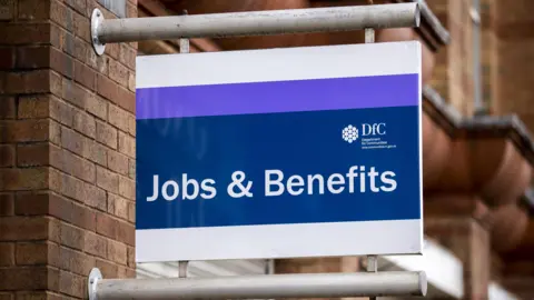 A blue and purple signs that reads "Jobs & Benefits" with the logo of the Department for Communities 