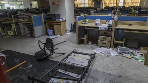 Anadolu via Getty Images Newspapers strewn across the floor, chairs overturned in the wrecked Daily Star newsroom after the attack.
