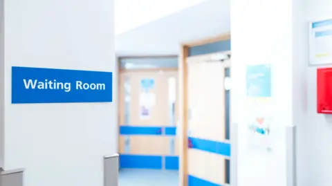 Getty Images Typical hospital and GP waiting room sign seen within a patient's medical waiting area. Corridors leading to various medical units.