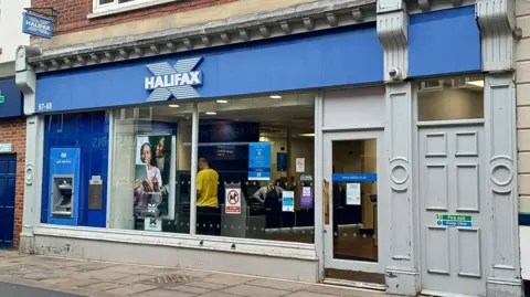 LDRS/ Emma Atkins The front of a Halifax bank, with a cash machine on the left. A man in a yellow t-shirt can be seen inside the bank.