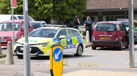 Supplied A parked police car with officers standing nearby.