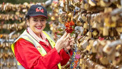 Rows of locks with Emma Harrison wearing hi vis stood next to them