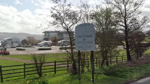 Google Maps Sign for Cheltenham Spa, with Cheltenham Racecourse in the background