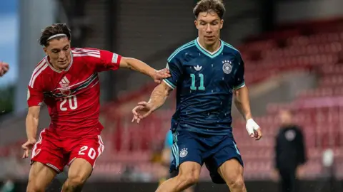 Wales' Charlie Stevens battles for possession with Moritz Reimers of Germany