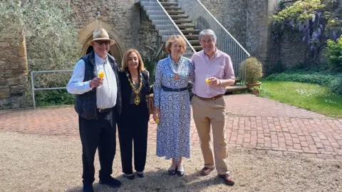 The Friends of Abingdon Abbey Buildings Trust Two men and two women celebrating at the Abingdon Abbey Buildings to mark the fund award. They are holding glasses with orange juice and smiling for teh camera. One of the women wears a mayoral chain.
