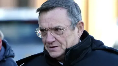 PA Media Derek Green is pictured outside a court. He has combed grey hair and wears a dark jacket and glasses