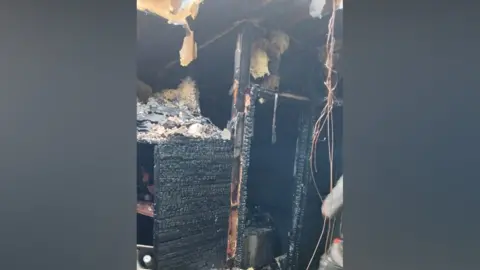 Tom Elliott A cupboard is black from heavy charring.