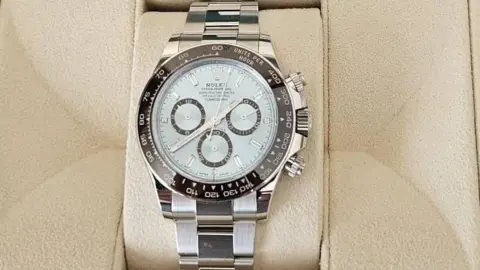 Nottinghamshire Police A close up image of one of the stolen watches, a silver Rolex analogue watch sat in beige padding