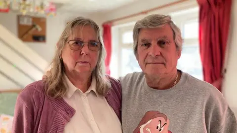 Picture taken of Gary and Alison Eden standing together in their home. 