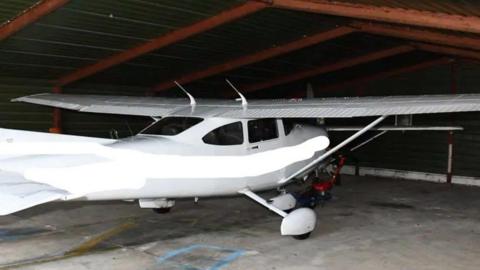 A white Cessna light aircraft pictured in a hangar 