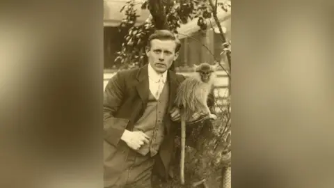 A man standing next to a monkey