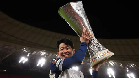 Tottenham captain Son Heung-min holds the Europa League trophy after his team's win against Manchester United in Spain