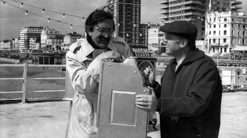 Getty Images Len Deighton and Richard Attenborough photographed during filming for Oh! What A Lovely War.  This is a black and white photo taken on a pier.