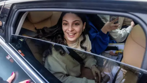 Reuters Daniella Gilboa seen smiling through the open window of a car where she sits in the back seat as she is welcomed home to Israel on 5/2/2025