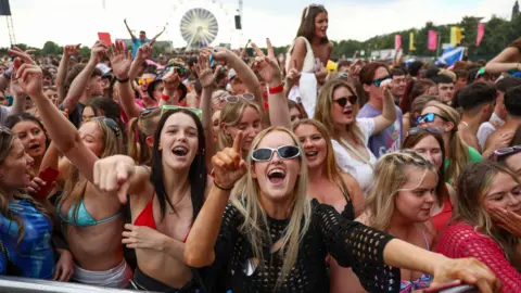 Getty Images A cheering crowd at the TRNSMT music festival. Many are singing along or have their arms in the air.